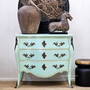 Shot of the chest styled in a hallway with vintage décor, adding bold colour and personality.