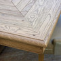 Close-up of carved geometric apron detailing on the Chesterton oak dining table.