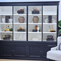White shelves styled with books, ceramics and glassware for a refined coastal look.
