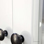 Close-up of the brass metal knobs on the white drawers, offering a clean contrast and timeless finishing touch