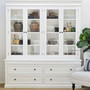 Front view with soft lighting, showing the contrast between the white frame and dark interior decor pieces.


