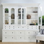 Top hutch doors open and shelves styled with books and coral for a coastal interior look.