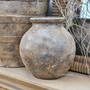 Angled image of the Ismara vessel on a timber console, showcasing its soft form and earthy, mineral-washed surface.