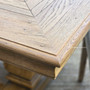 Close-up of where the parquetry pattern meets the table edge, illustrating the clean craftsmanship.