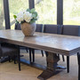 Cigar oak dining table shown in a modern dining room setting.