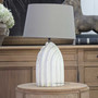 Margaux table lamp in distressed off-white with taupe shade on side table