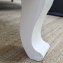 Close-up of the Genevra Coffee Table’s curved legs and smooth painted finish.