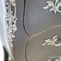 Close-up of the carved side bracket detail, featuring patina contrast and elegant lines.