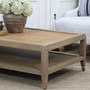Angled view of the Haddon Rattan Coffee Table highlighting natural timber legs and rattan panel detailing