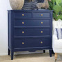 Angled view of the Navy Blue Peninsula 5 drawer chest styled in a modern living space with decorative accents.