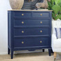Angled view of the Navy Blue Peninsula 5 drawer chest with limewash top styled in a modern living space with decorative accents.