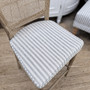 Close-up of the Noda Chair Blue Stripe Cushion in woven ticking fabric, showing the piped edge detail and soft linen-blend texture designed to complement the rattan seat.