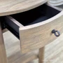 Close-up angled view of the Luna Side Table featuring its half-moon silhouette and natural timber detailing with open drawer showing the metal runner