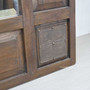 Tight detail shot of the carved lower panel showcasing its unique, rustic aesthetic.