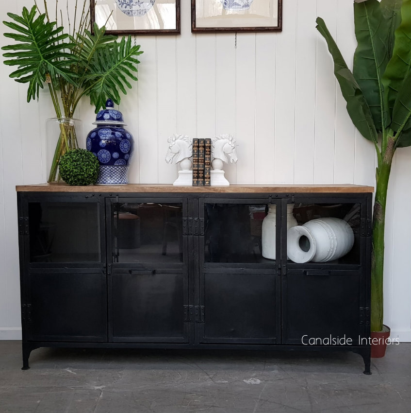 Perfect for a coastal-themed lounge room, the Foundry Industrial TV Sideboard by Canalside Interiors provides a stylish distressed charcoal storage solution with a warm wooden top