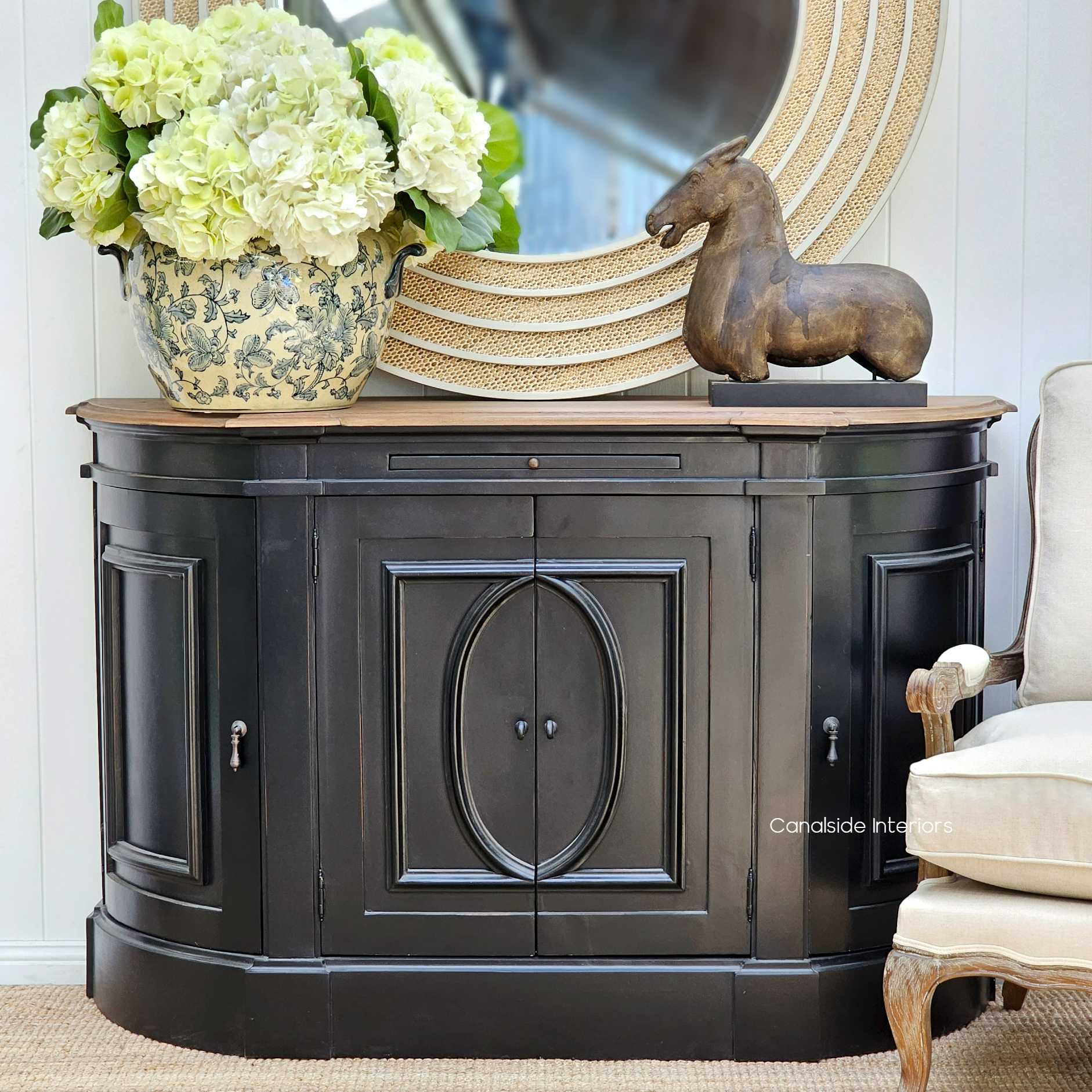 Frontal view of Bastian Small Sideboard in Distressed Charcoal Black featuring a weathered oak top, showing the classic curves and intricate detailing, perfect for adding a Hamptons touch to your bedroom or living room - Canalside Interiors.