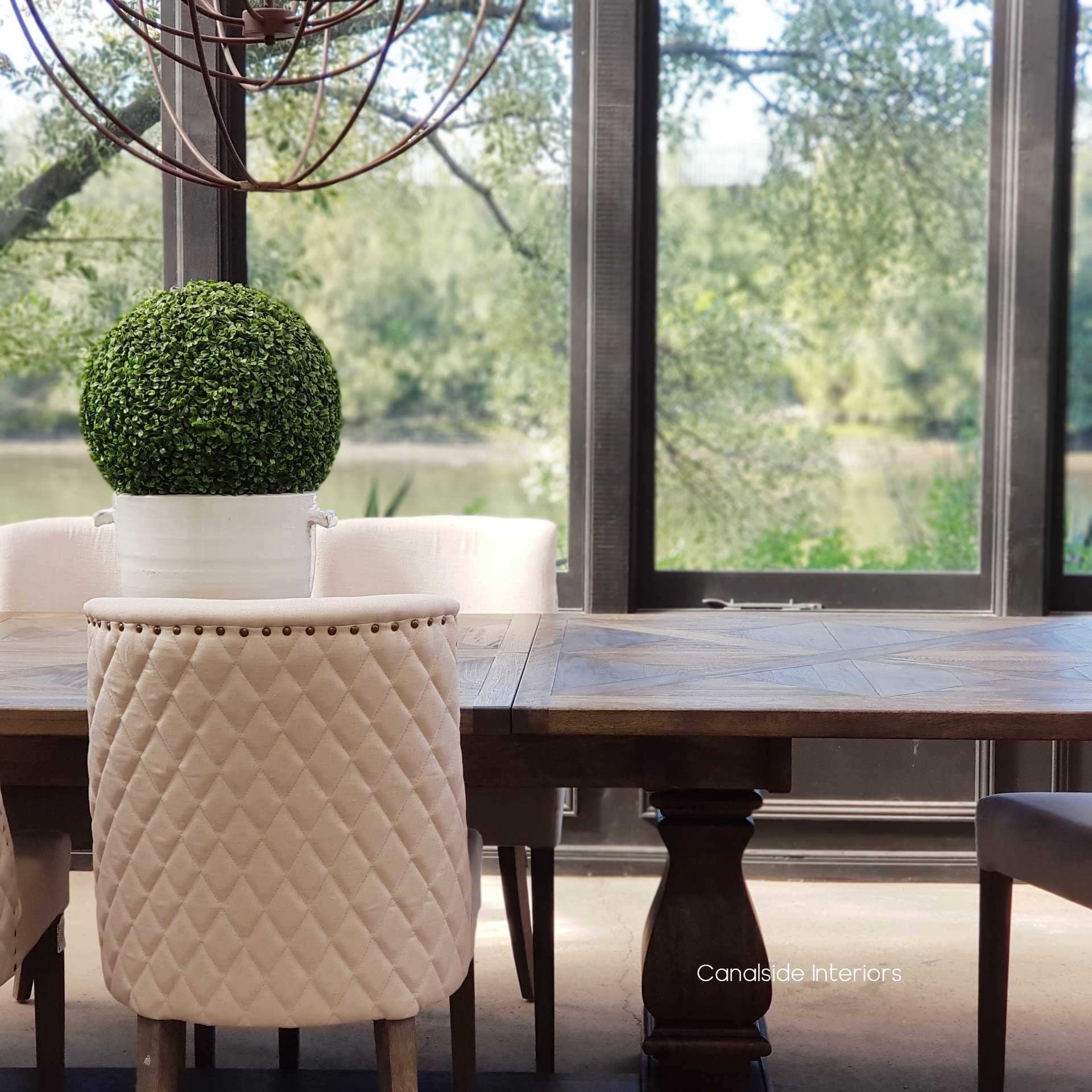 The Bridgehampton Parquetry Extendable Dining Table, with its dark, rich tones, stands as a centerpiece, ready to transform from an intimate setting to a spacious entertaining surface