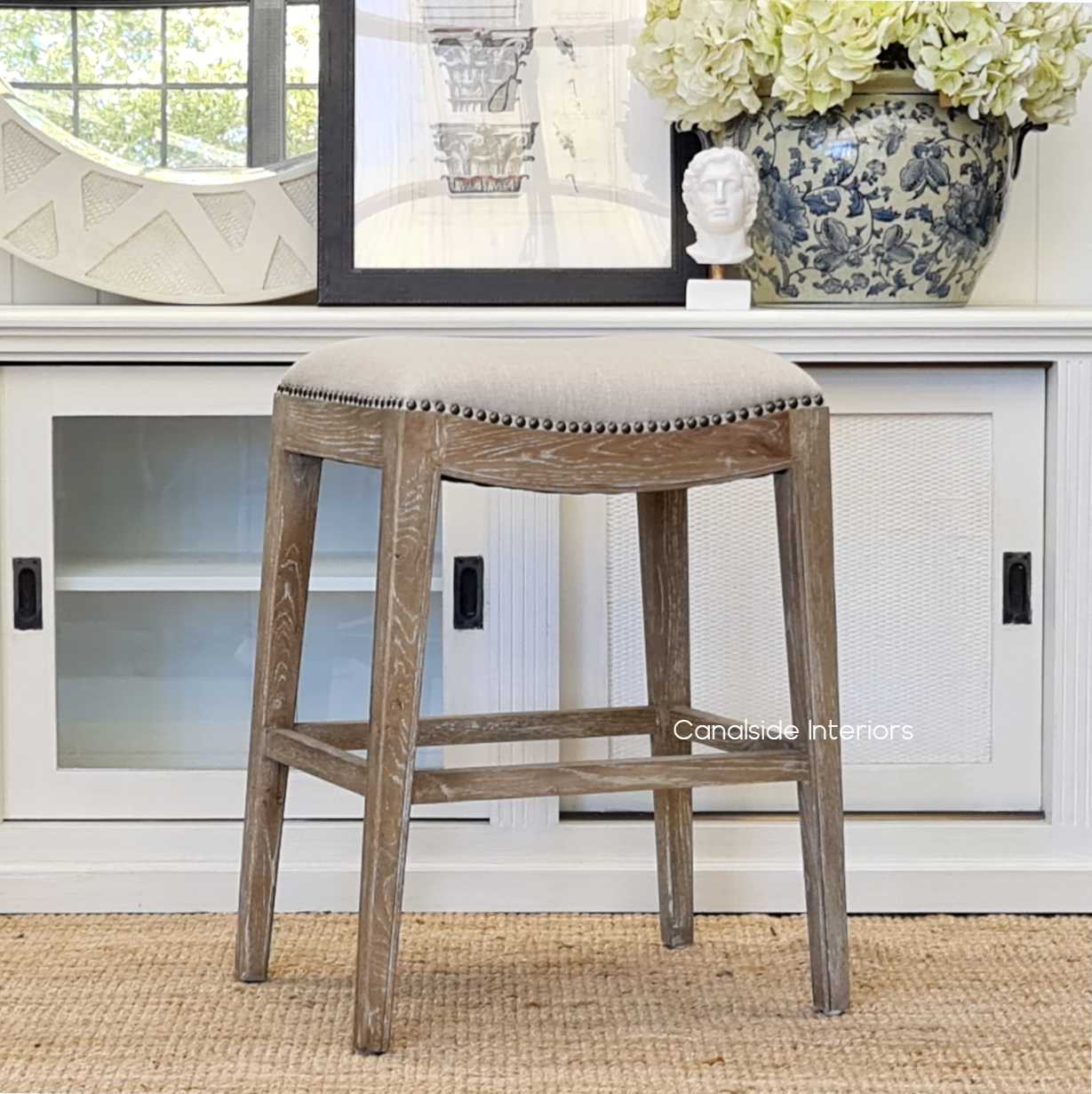 Front view of Mila II Upholstered Kitchen Bar Stool with cream upholstery and weathered oak base - perfect for adding a contemporary touch to any kitchen island.