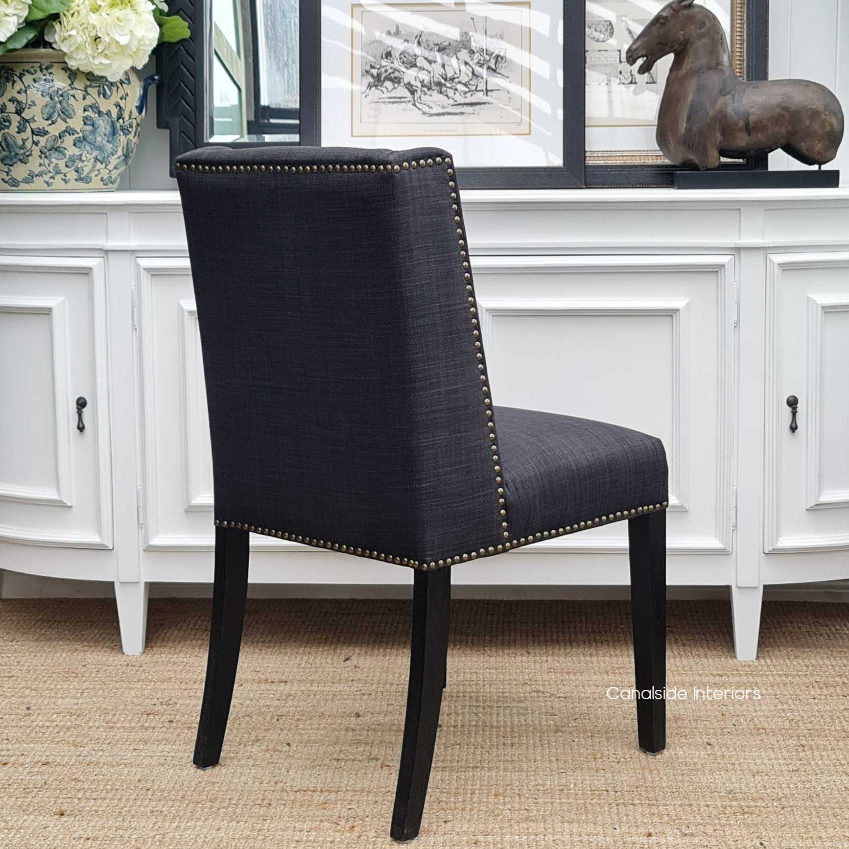 The dark hues of the Leclerc Dining Chair offer a dramatic yet elegant statement, perfect for enhancing a luxurious dining experience