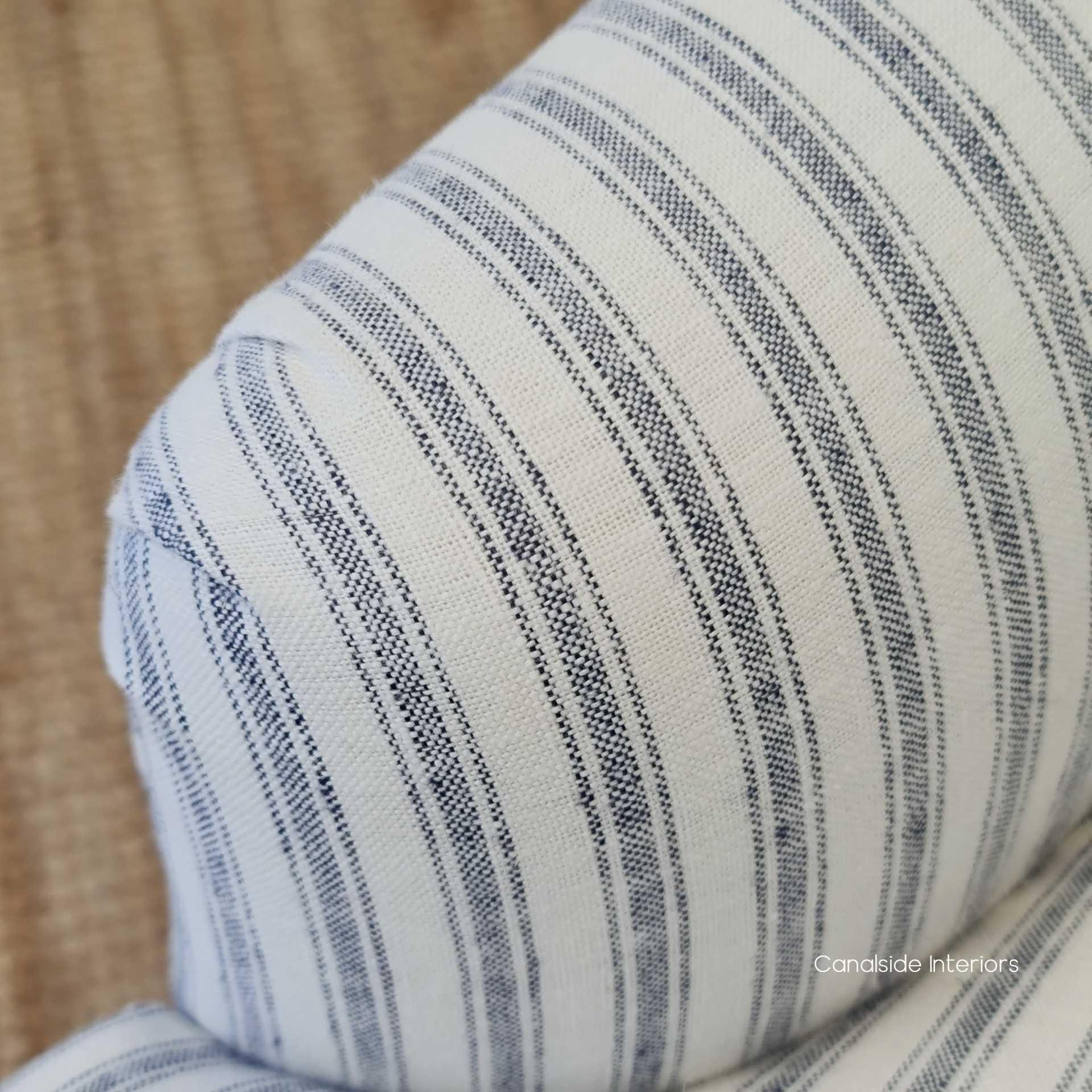 Close-up of the blue-striped linen upholstery on the Ascott Buttoned Armchair, perfect for a Hamptons-themed bedroom.