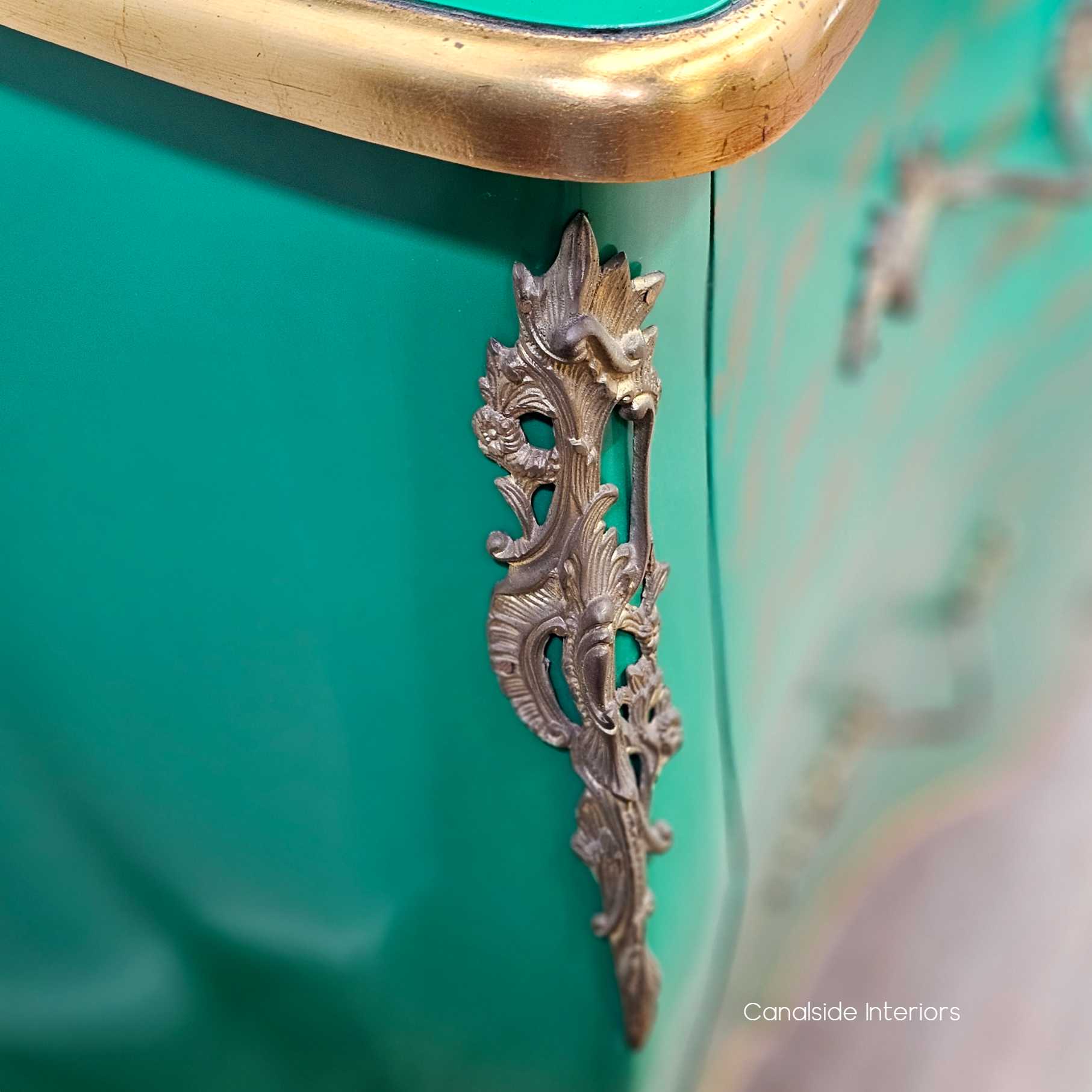 Close-up of one side panel, showcasing the soft curve and smooth painted finish with gold accent features.