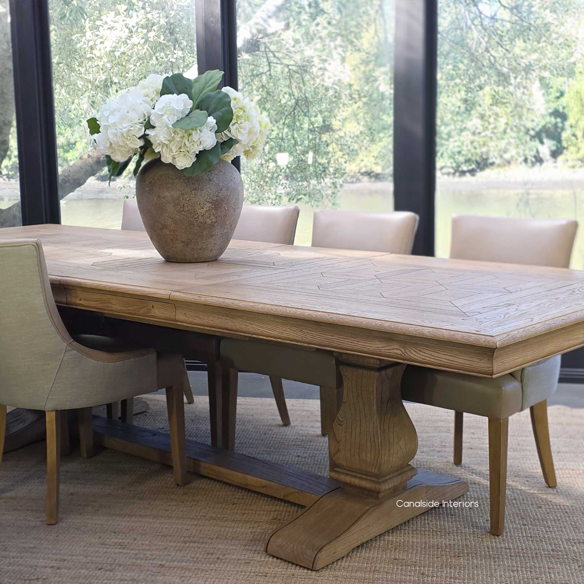 Chesterton Double Extension oak dining table styled with leather upholstered dining chairs.