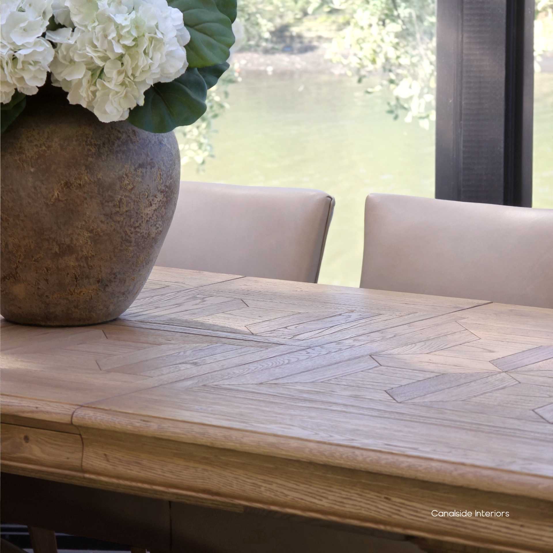 Rich oak tones of the Chesterton parquetry tabletop highlighted in a close-up shot.