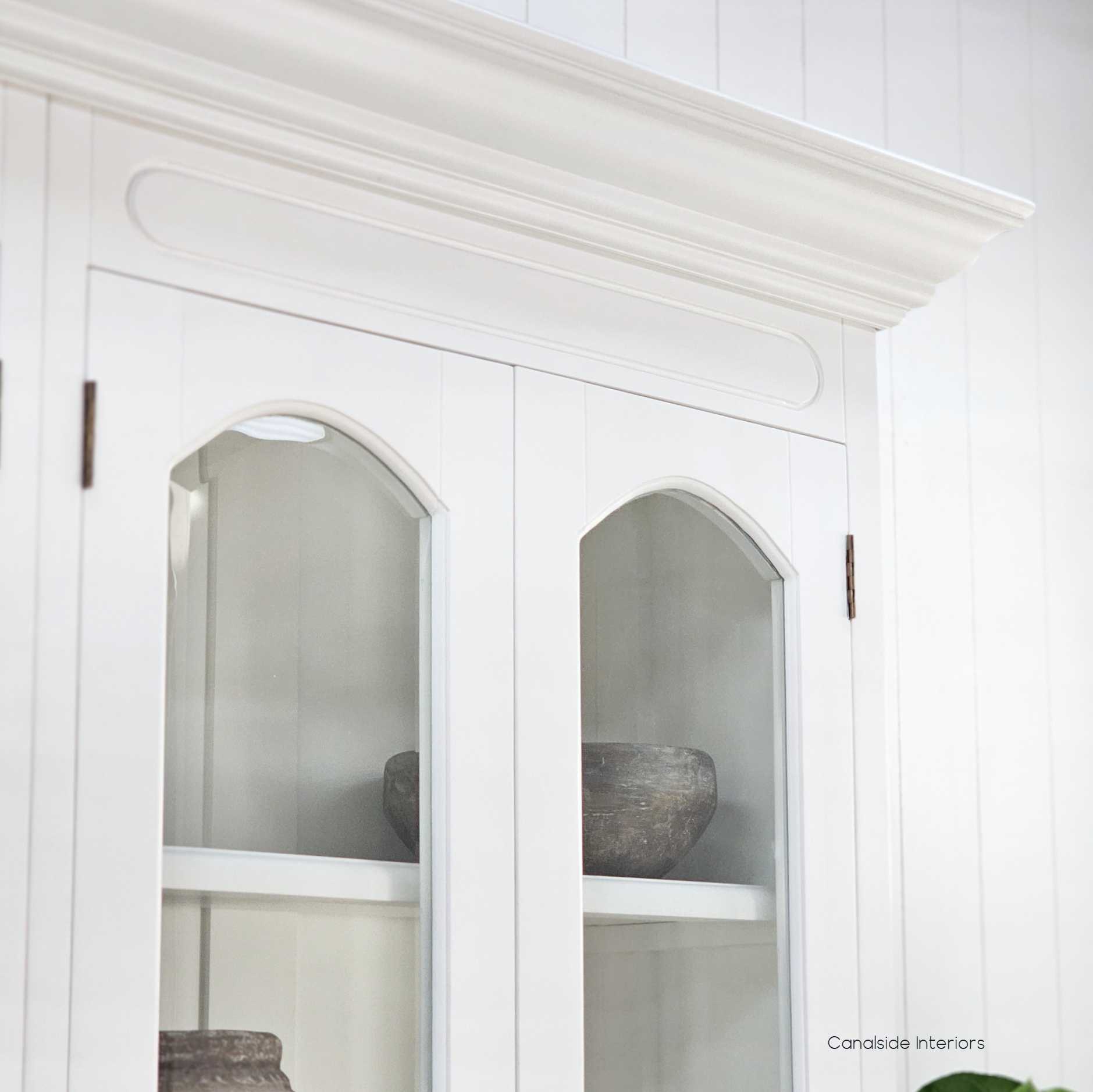 Detailed view of the crown moulding and arched door frames, highlighting the classic proportions and traditional design influence.