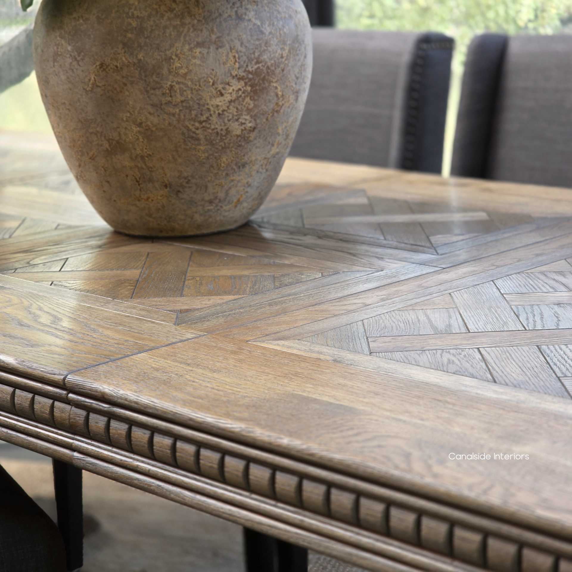 Detailed view of carved geometric apron on Cigar oak table.