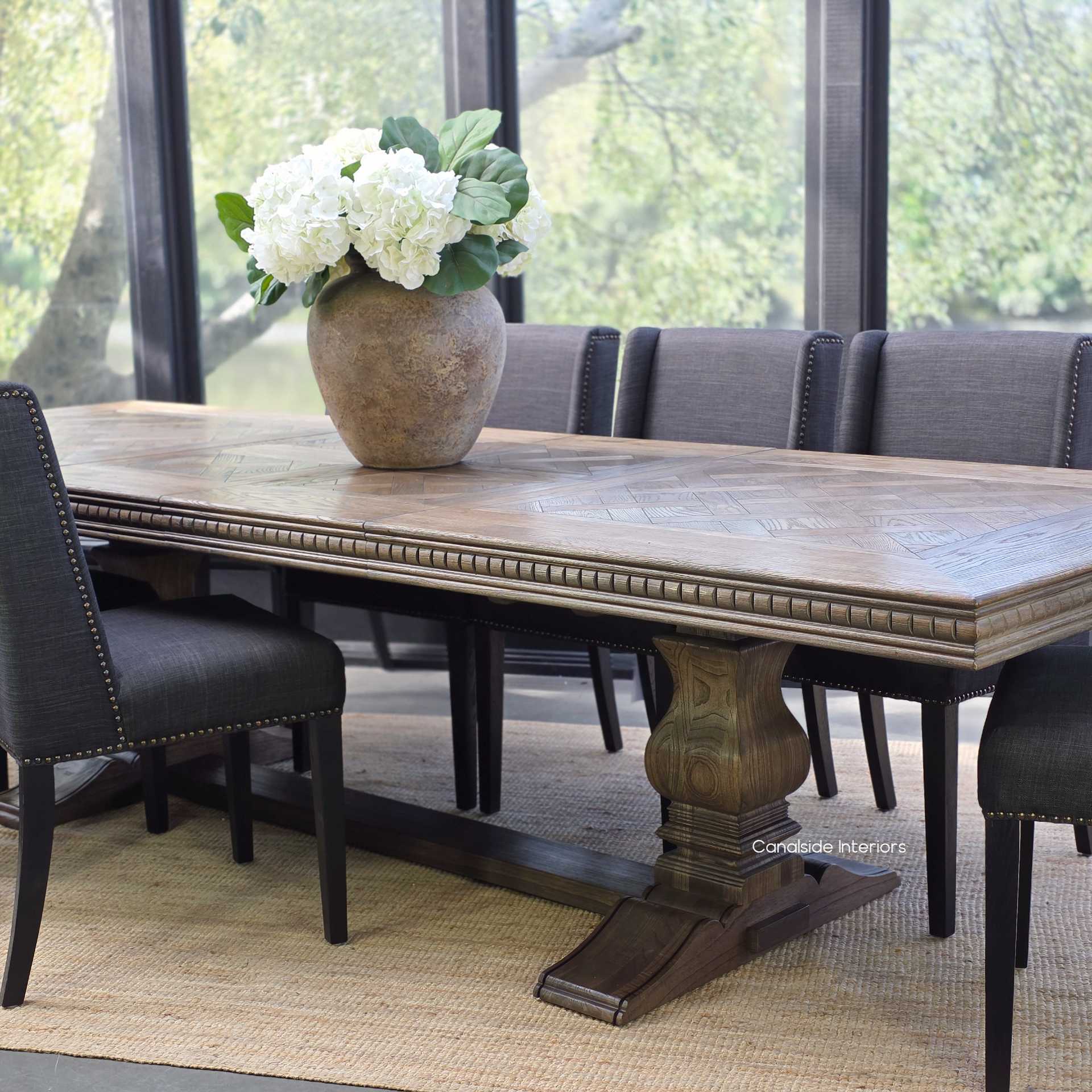 Formal dining arrangement with Berenson parquetry table in Cigar and high-back upholstered chairs.