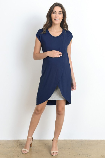 A navy short sleeve maternity and nursing dress featuring a rounded neck line, an asymmetrical hem and grey underlining.