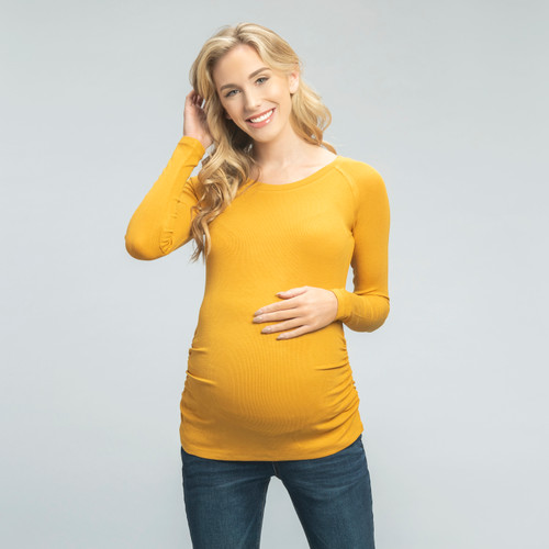 A fitted maternity top in a ribbed knit material featuring a rounded neckline, long sleeves and ruched sides.