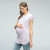 A solid hued maternity top featuring short crochet sleeves, a knotted hem and a rounded neckline.