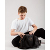 Young male dancer opening the main compartment of the black Nova Dance Bag to show the spacious internal storage.