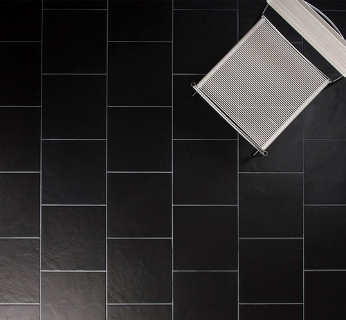 Johnsons Lagos Black Slate Effect Porcelain Tiles used as dark floor tiles with a white chair