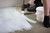 A tiler easily applying BAL Primer APD primer to a floor with a brush before laying tiles.