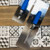 Two Genesis QUICKSWITCH Stainless Steel Trowel Blades pictured on a tiled floor