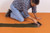 A tiler applying tile adhesive on top of Schluter Ditra Matting