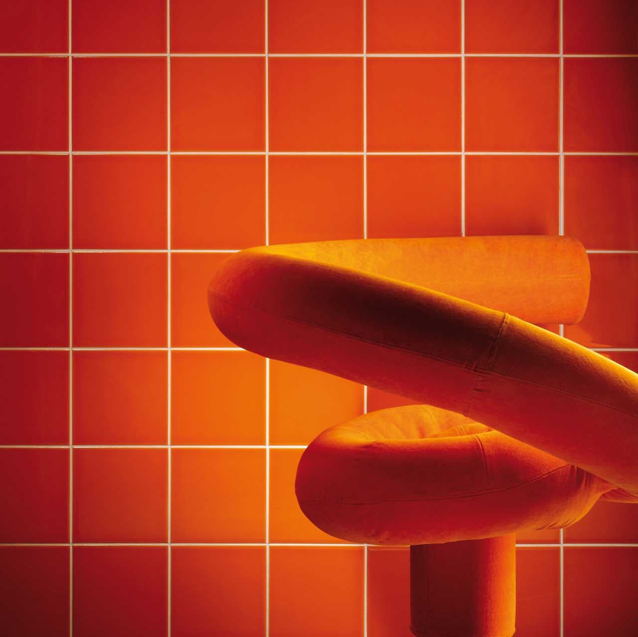 Johnsons Prismatics Square Gloss Pumpkin Red Tiles with a modern orange chair