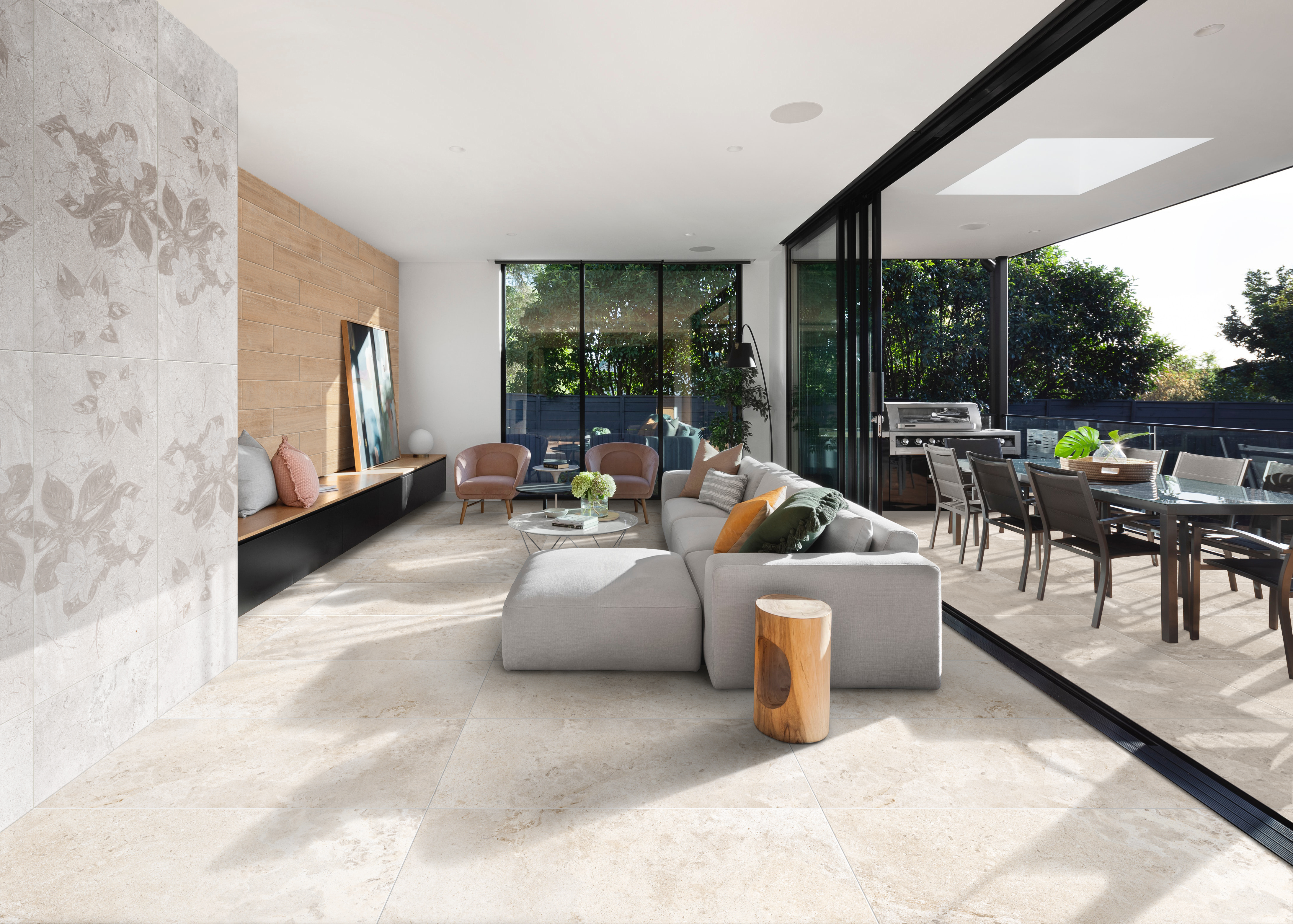 Light beige travertine effect floor tiles used in a living room with sliding doors and coordinating outdoor tiles on a patio