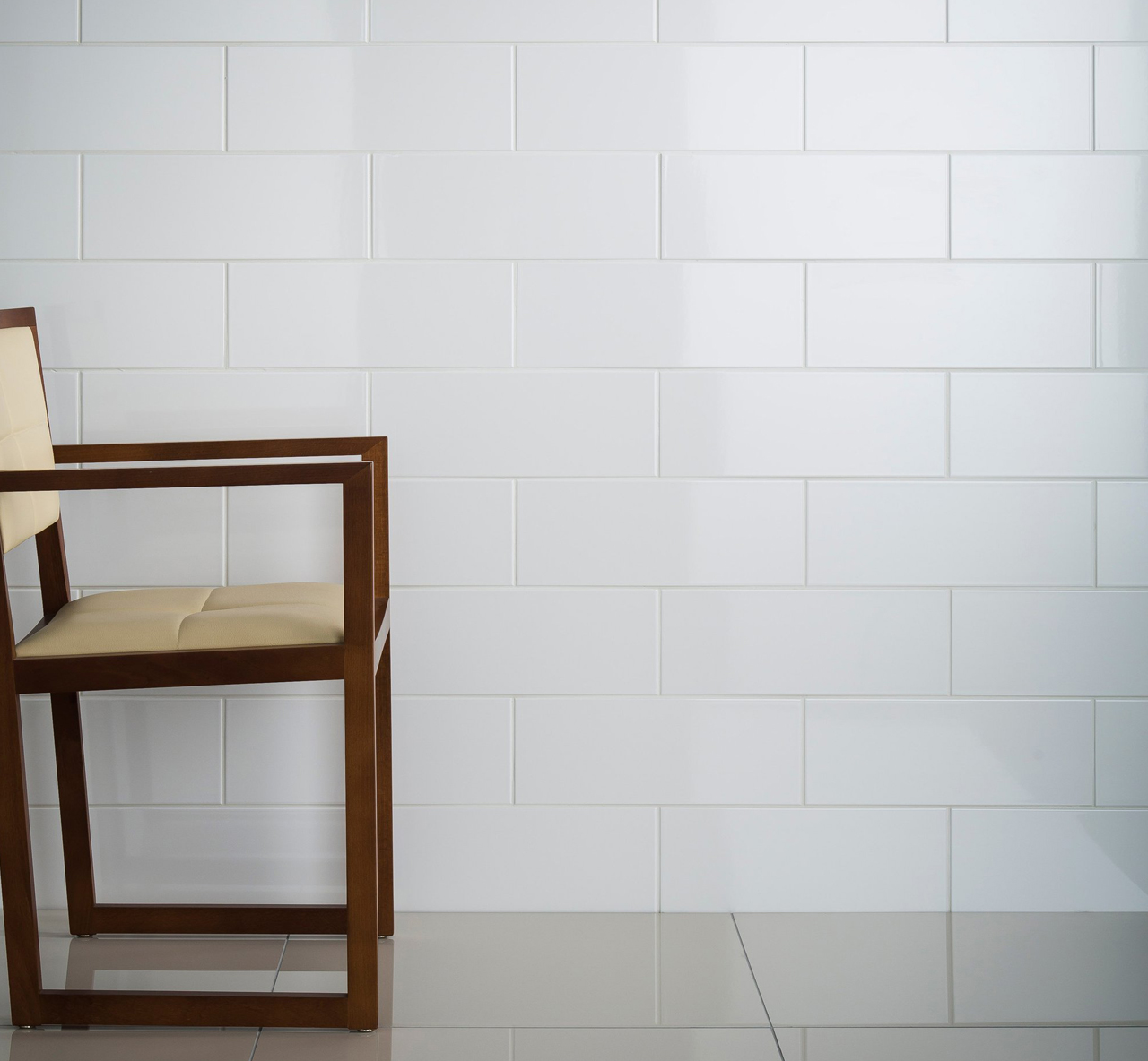 Johnsons Arctic White Gloss Wall Tiles used in a room with a grey floor and a wooden framed chair