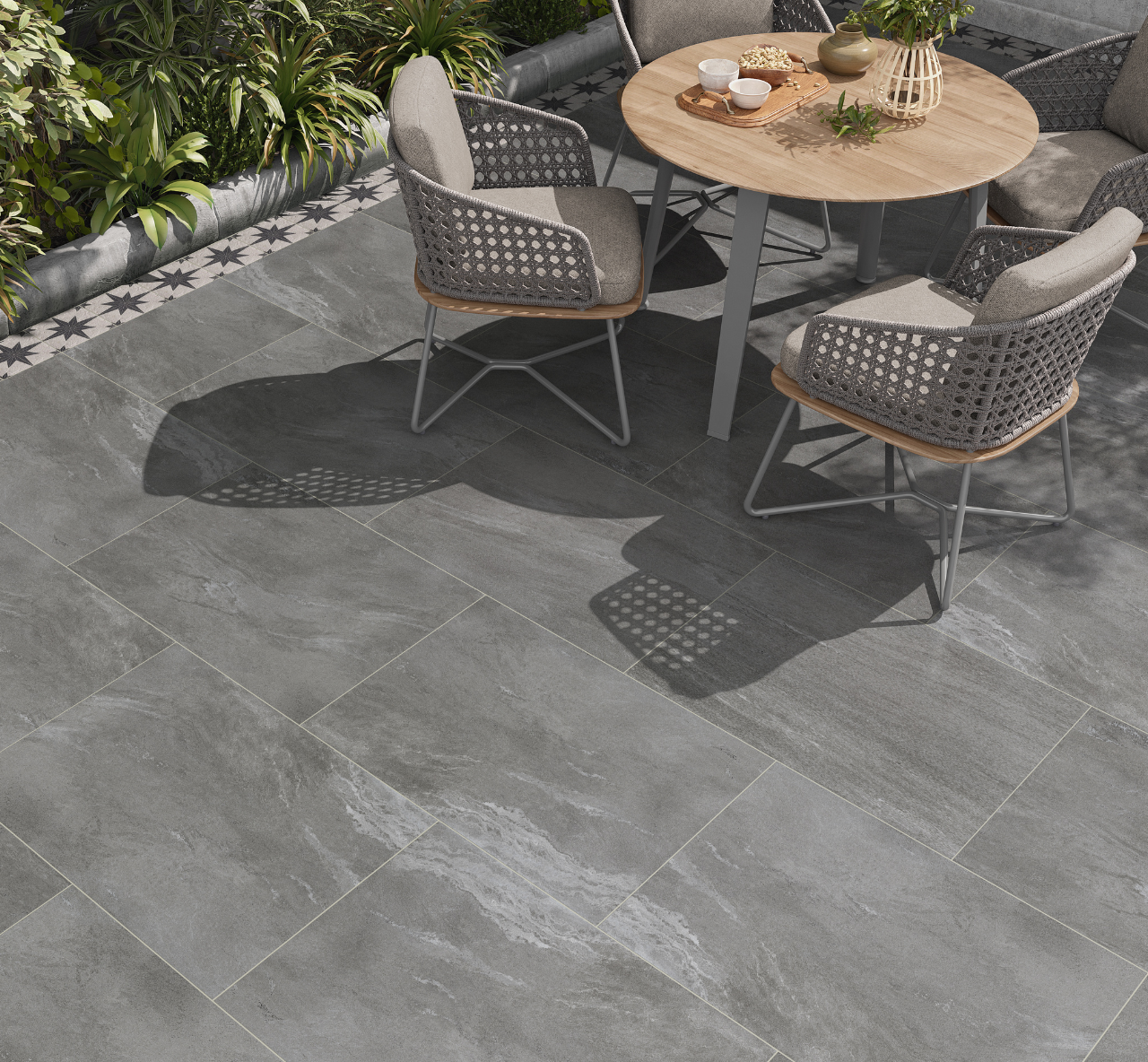 Vulcan Stone Effect Grey Outdoor Tiles used outdoors in a spacious sitting area with wooden outdoor furniture