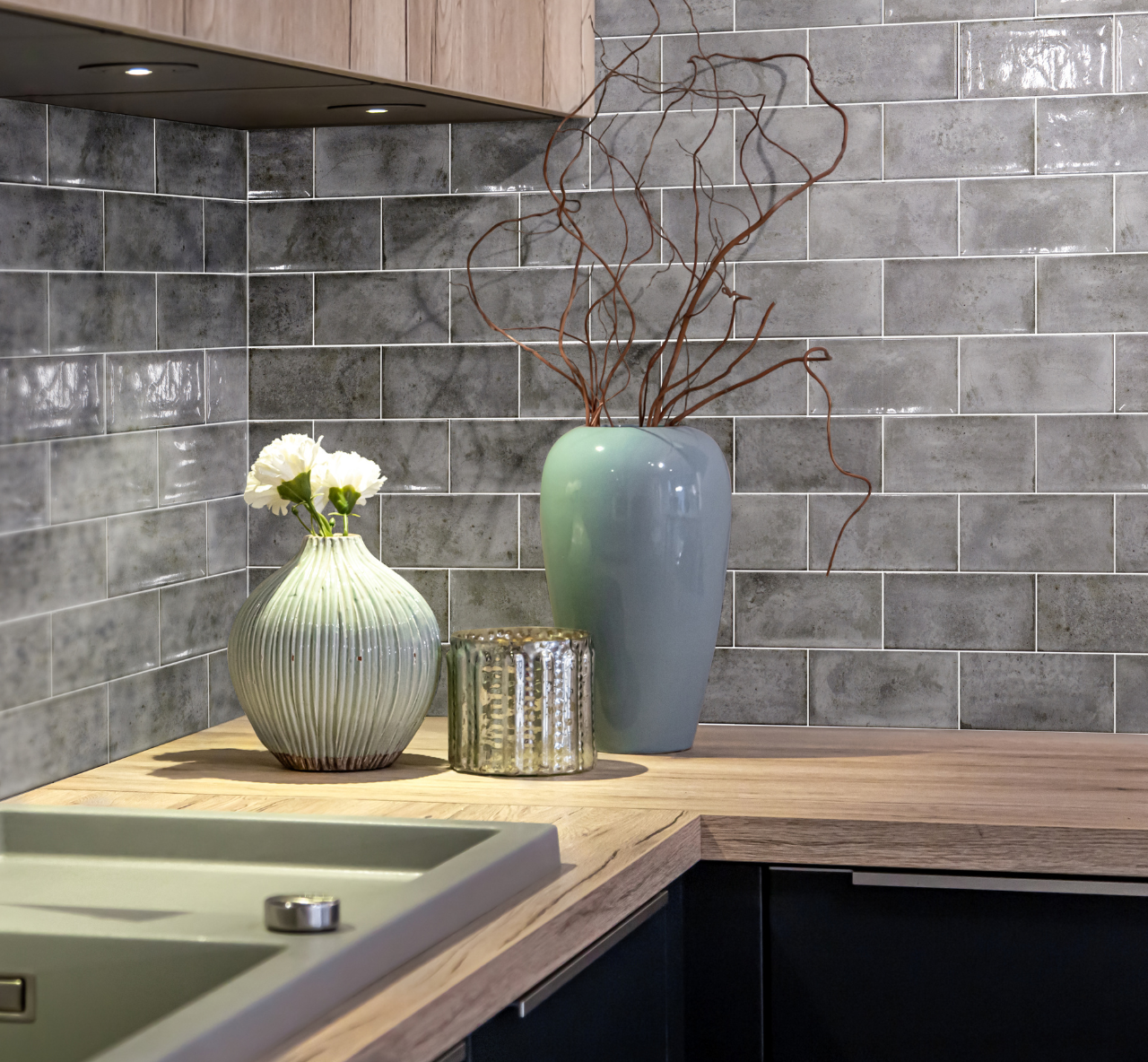 Silver grey distressed glossy metro tiles used on the wall in a kitchen