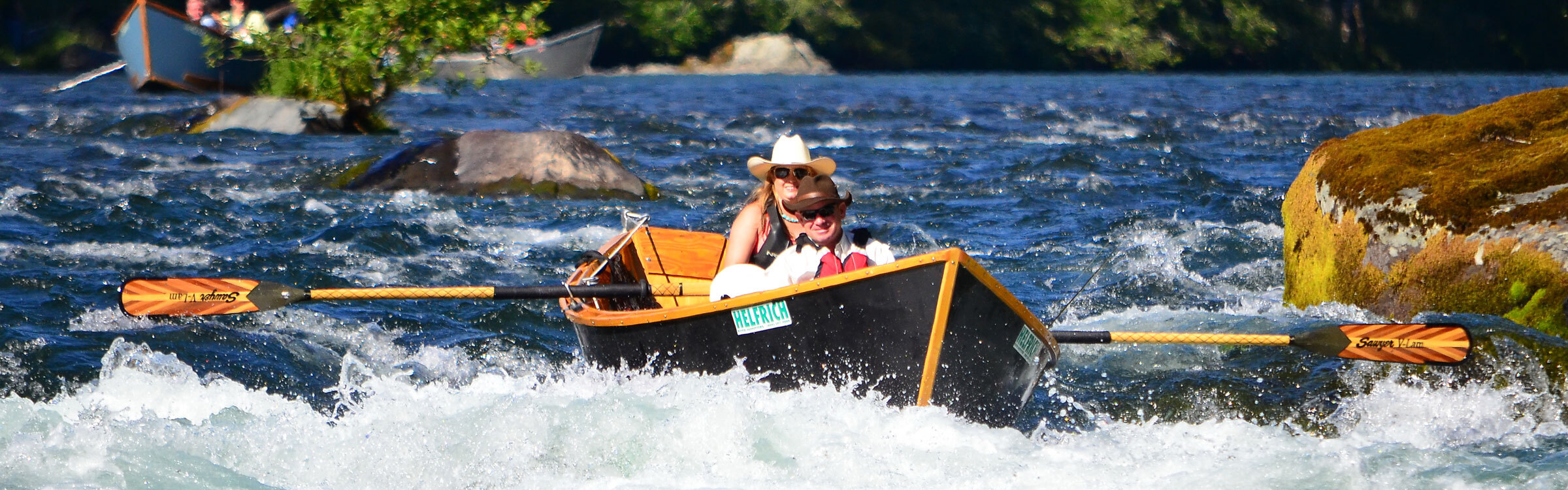 Kelsey Helfrich rowing a wooden drift boat