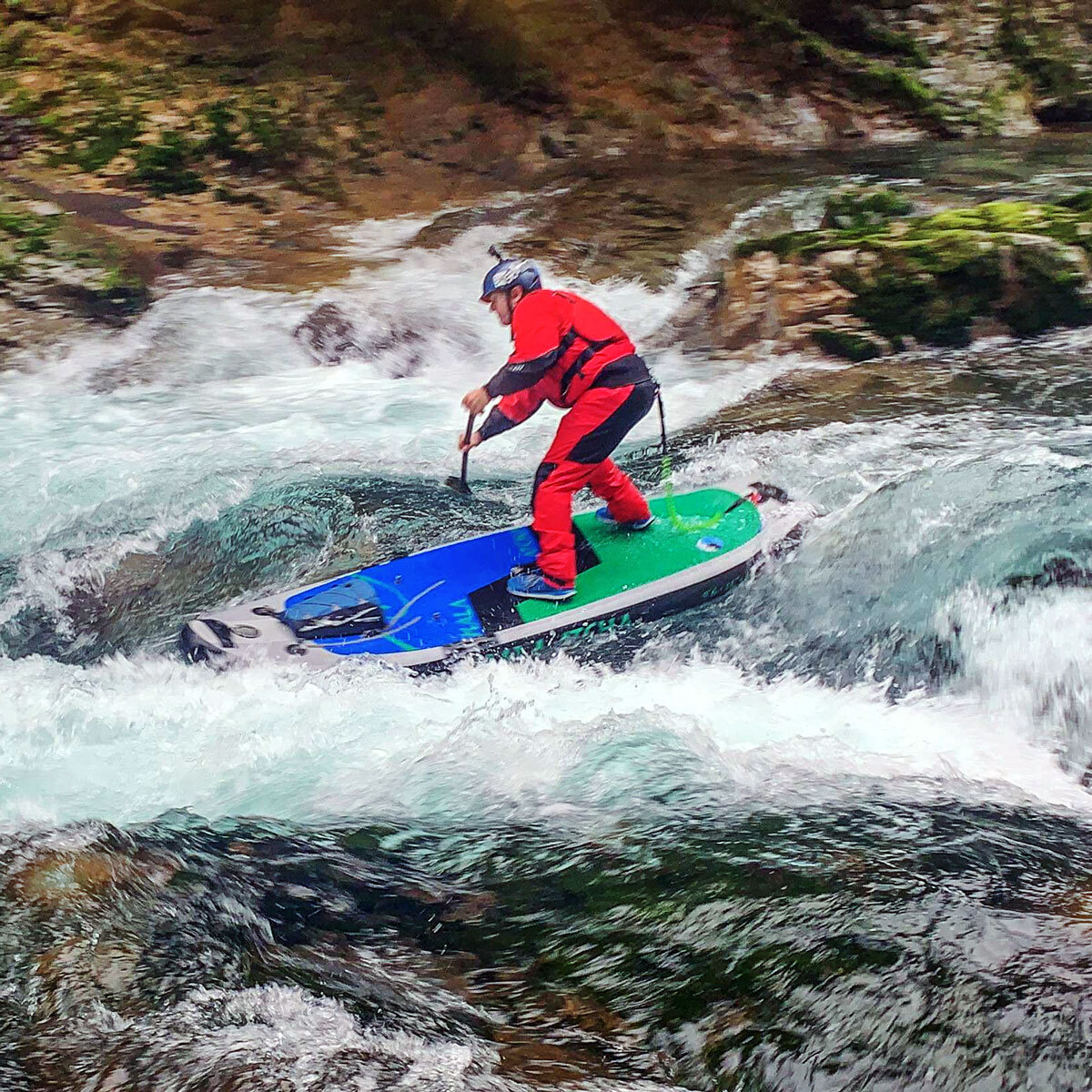 Paul Clark stand-up paddleboarding on a river