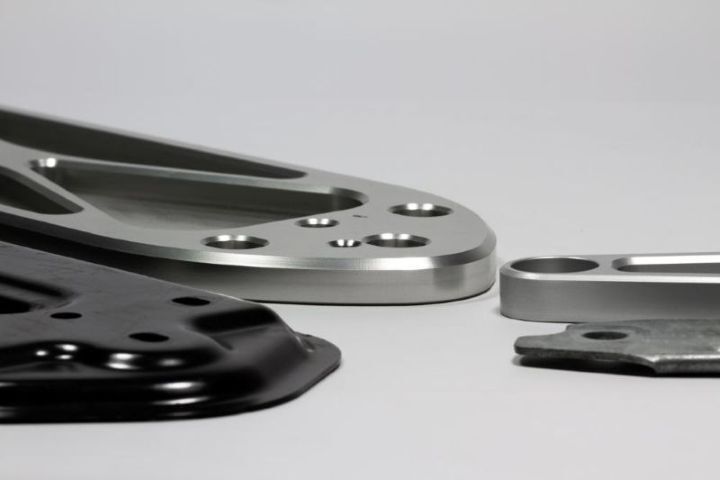 Comparison showing the heavy-duty Big Pair subframe braces next to the flimsy factory MINI Cooper F56 braces