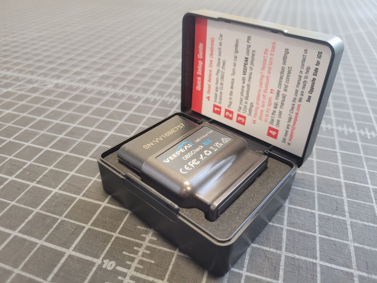 VeePeak Bluetooth OBDII Diagnostic Tool with the included case, top open and instructions visible
