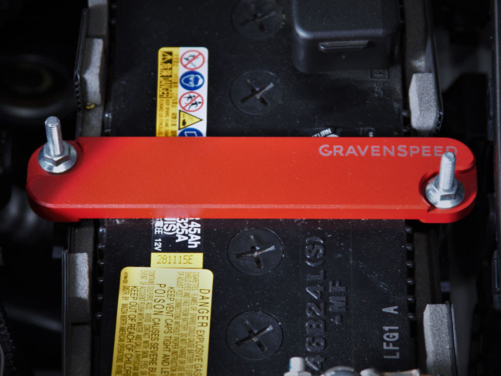 The CravenSpeed Battery Tie Down in red, installed in a 2016 ND Mazda MX-5 Miata.
