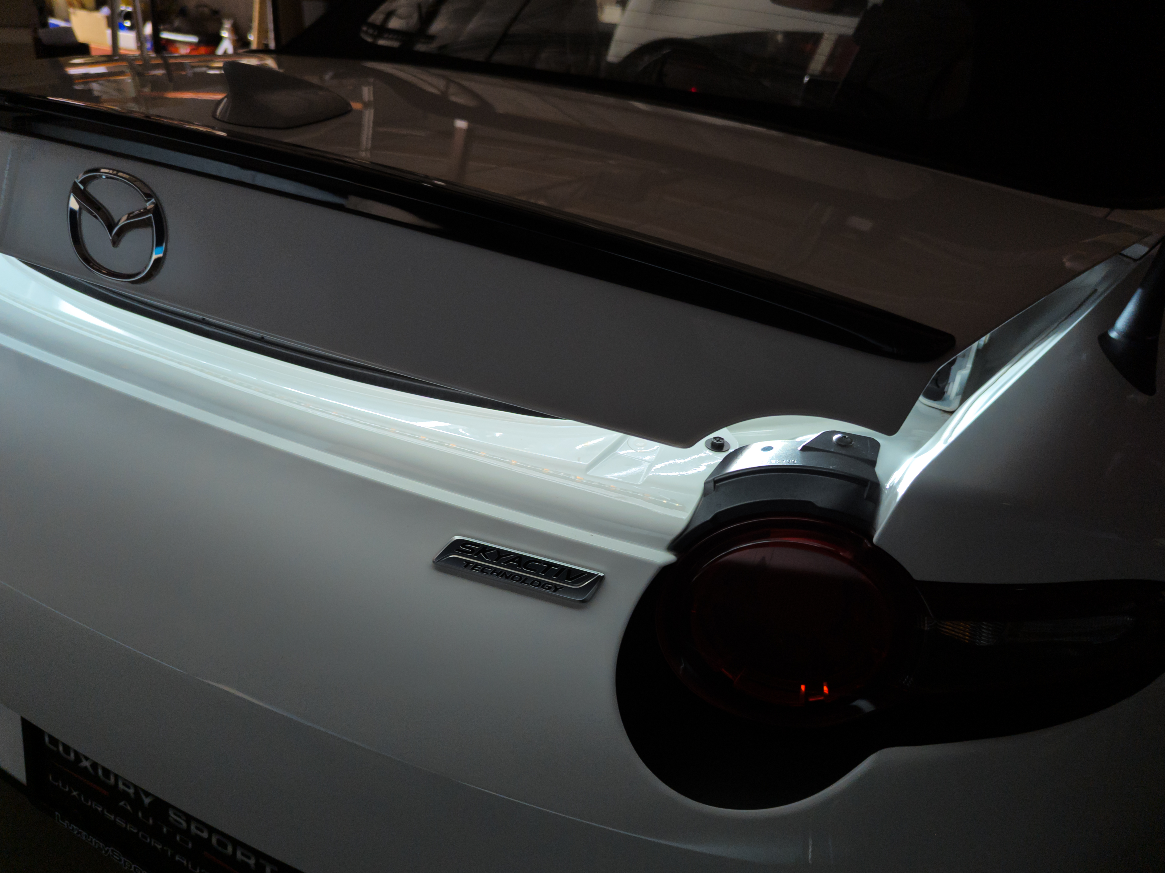 The trunk of the ND miata partially closed demonstrating that the led strip turns on as soon as the trunk opens.