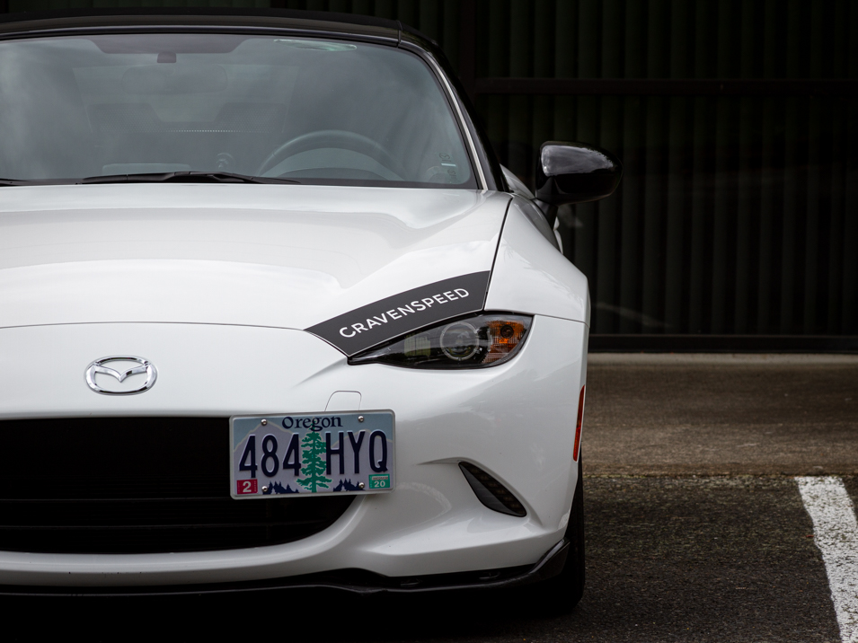 The CravenSpeed Graphics Kit and CravenSpeed Platypus License Plate Mount installed on a white 2016 ND Miata.